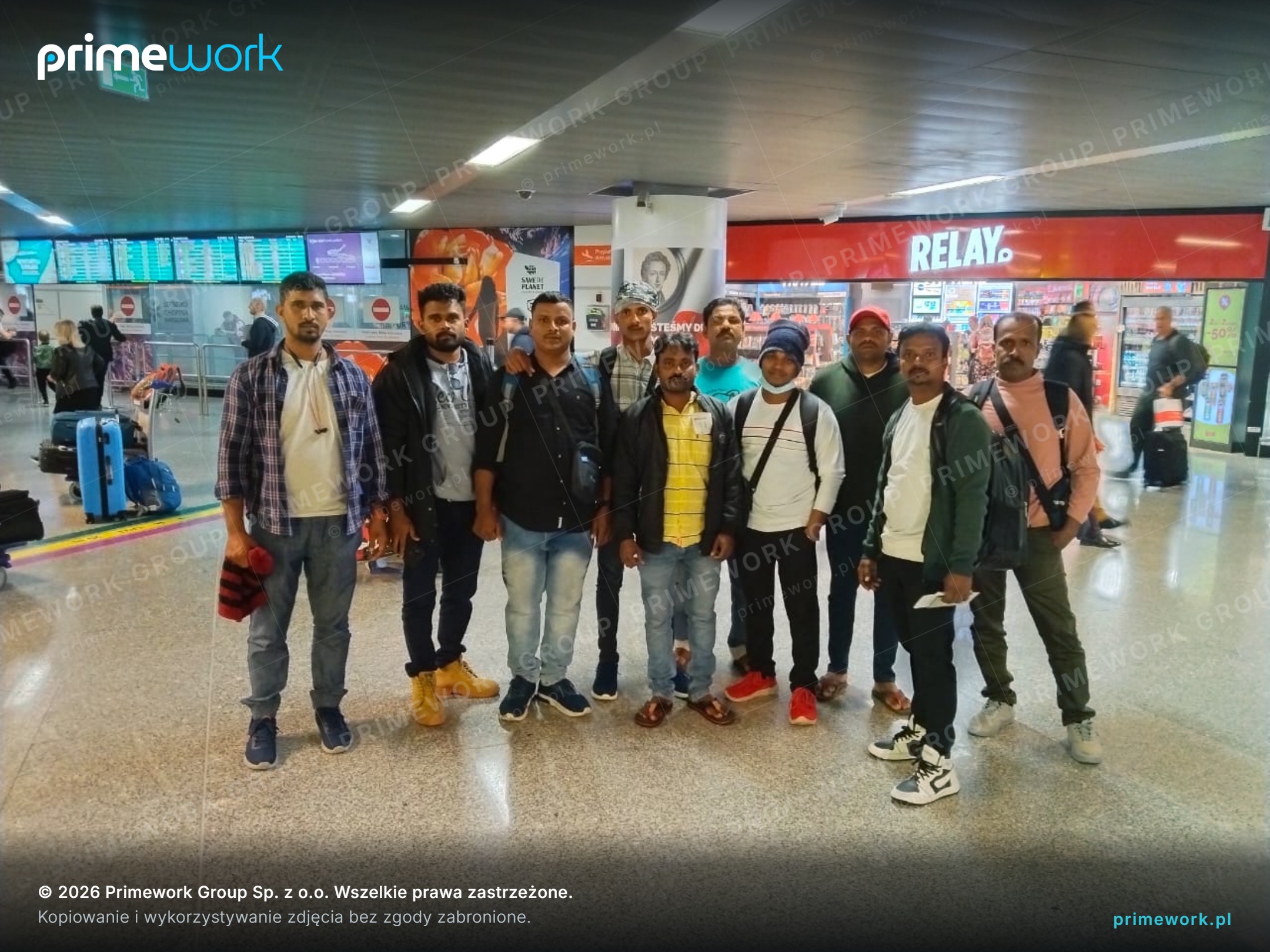 A group of workers from India in an arrivals hall