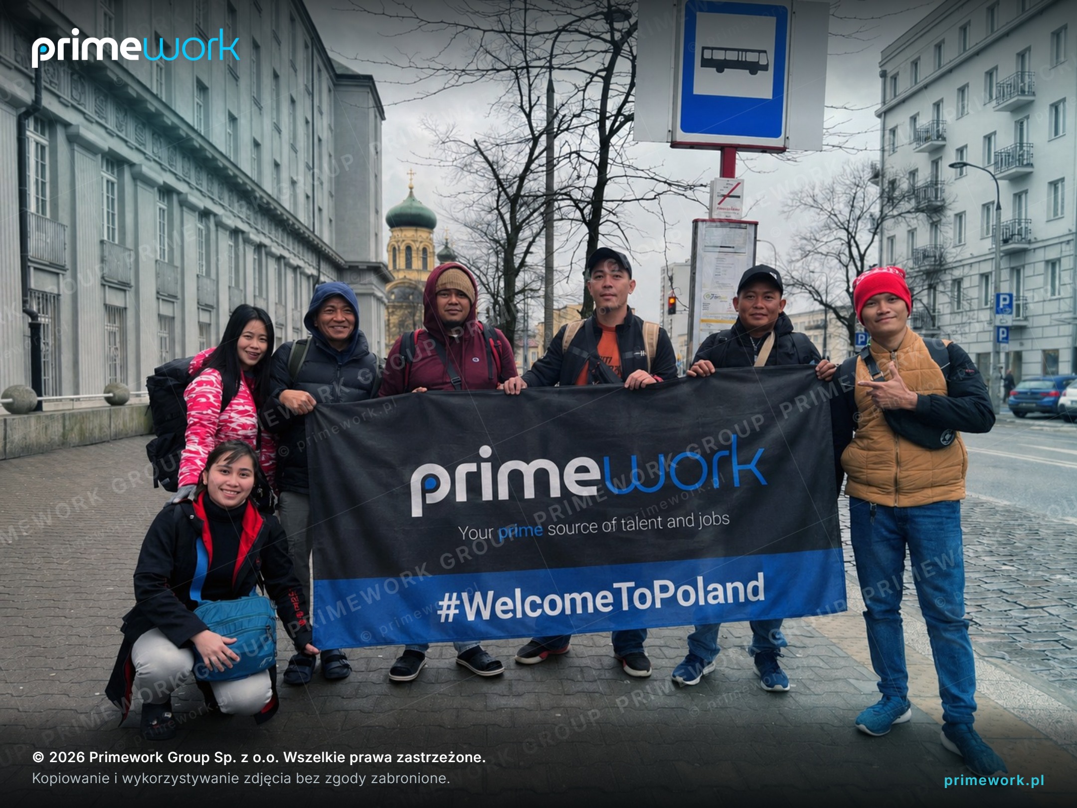 A group of Filipino workers with a Primework banner after arrival