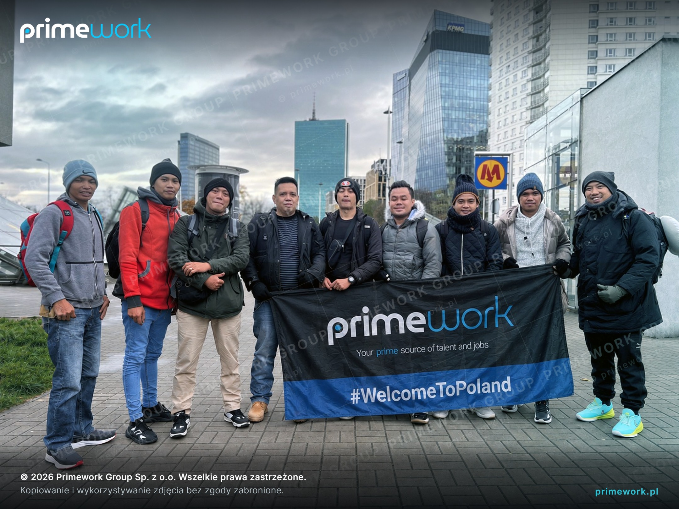 Група работници от Азия с банер на Primework в град в България